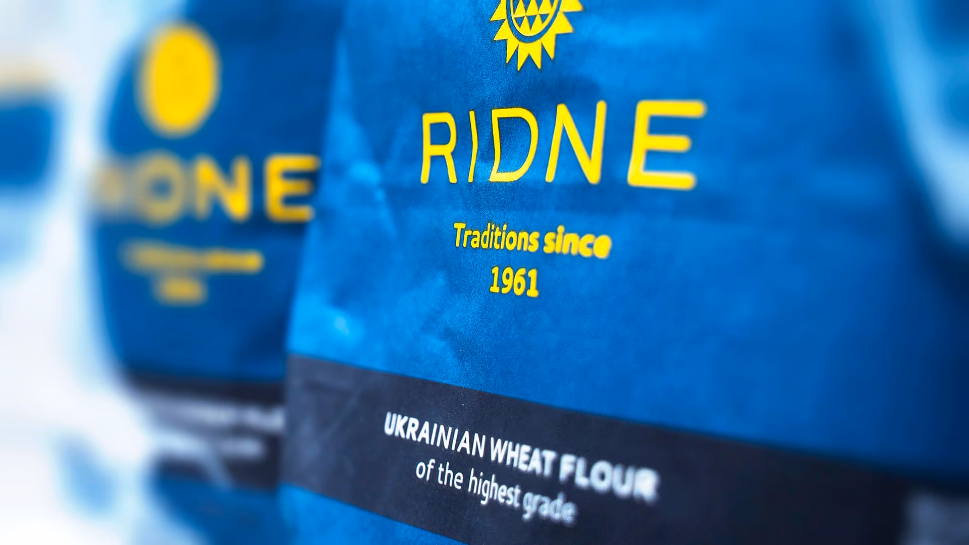 Blue bags labeled RIDNE wheat flour with text reading Ukrainian wheat flour of the highest grade.