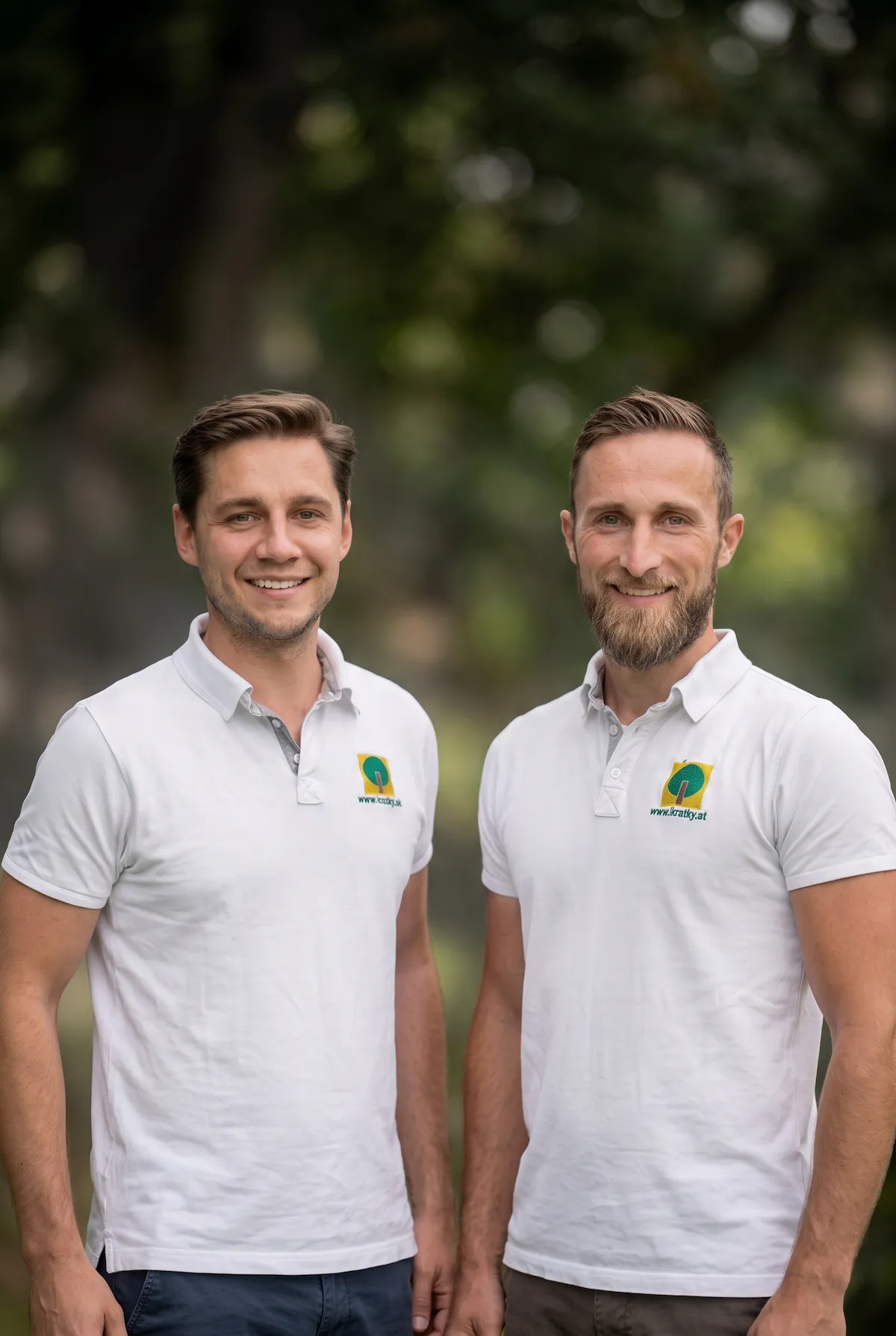 Zwei Mitarbeiter von Kratky in weißen Firmenpoloshirts vor grünem Hintergrund