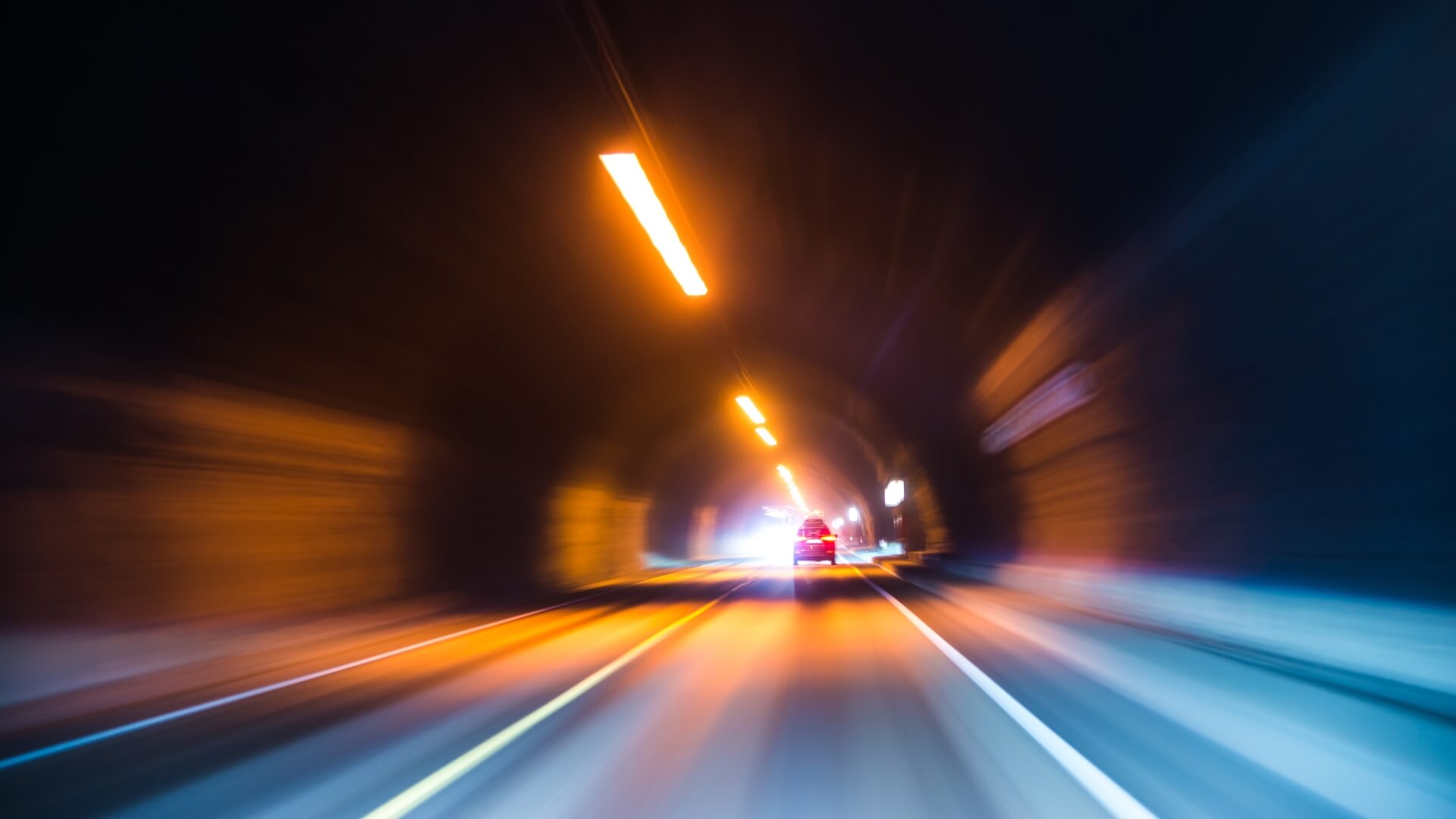 Vehicle travelling through a road tunnel monitored by an integrated infrastructure monitoring system.