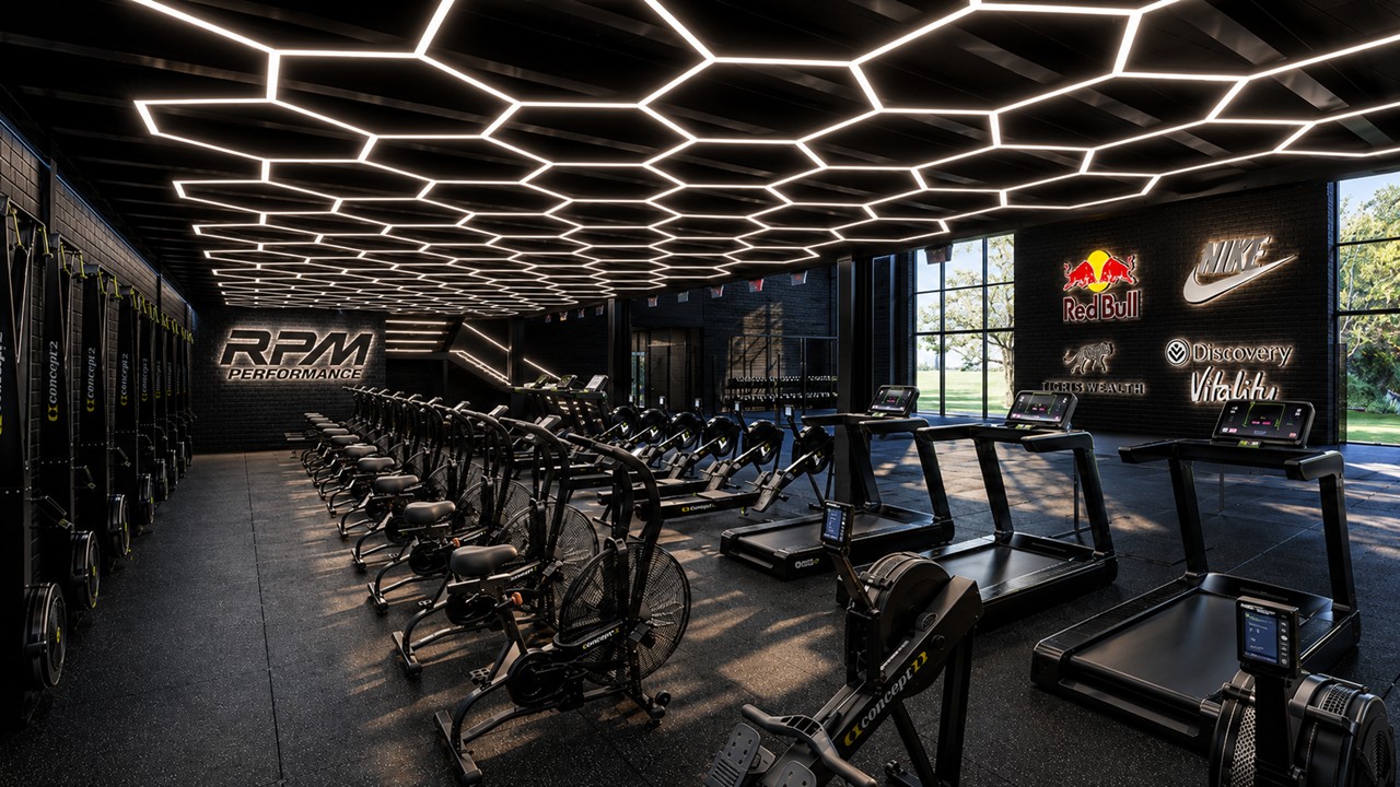 Modern gym interior with rows of exercise bikes, treadmills, and illuminated honeycomb ceiling lights.