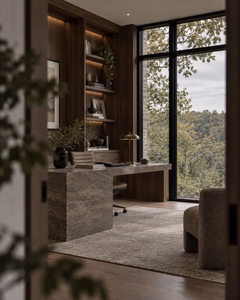 Organized home office with built-in shelving and a forest view