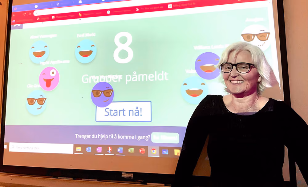 Bilde av matematikklærer Ellen Udnes foran tavlen som viser Diskusjon i Campus.
