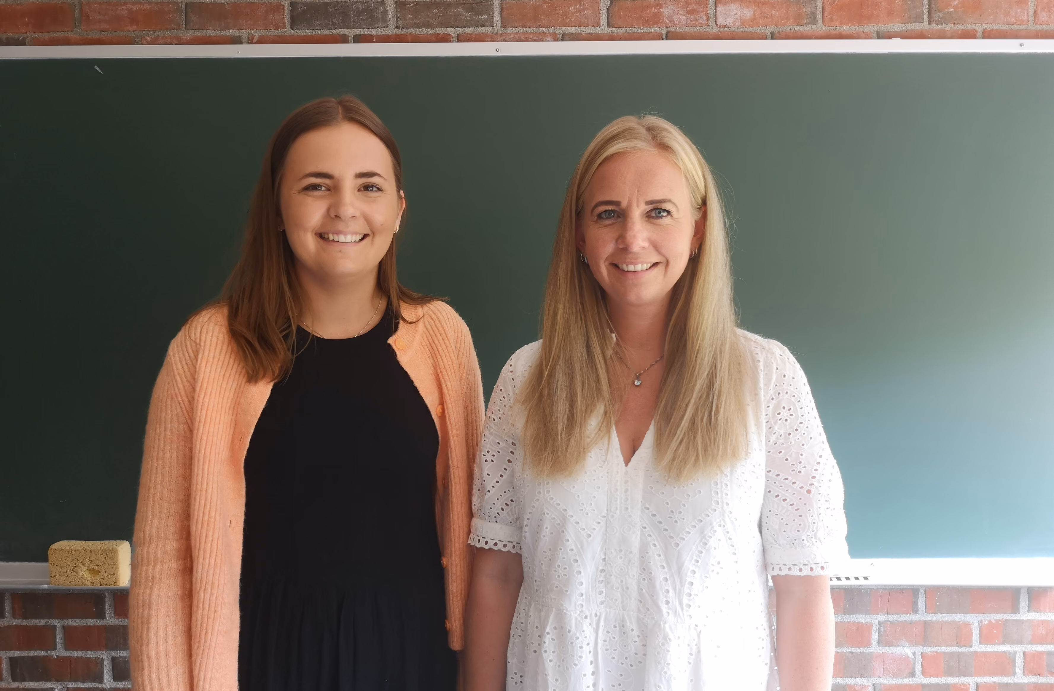Bilde av Inger Lise Bergheim og Celine Paulsen Hoffgaard foran tavlen.
