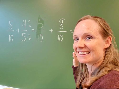 Bilde av Stine Wike foran tavlen.
