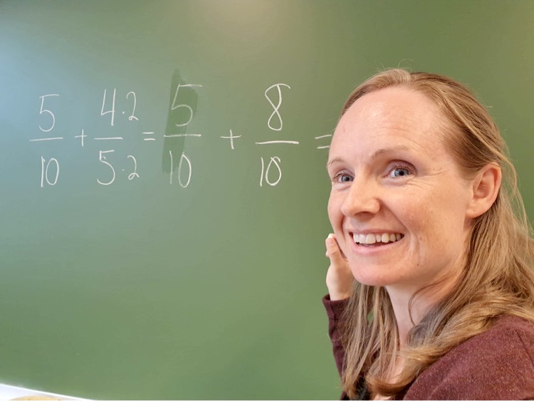 Bilde av Stine Wike foran tavlen.