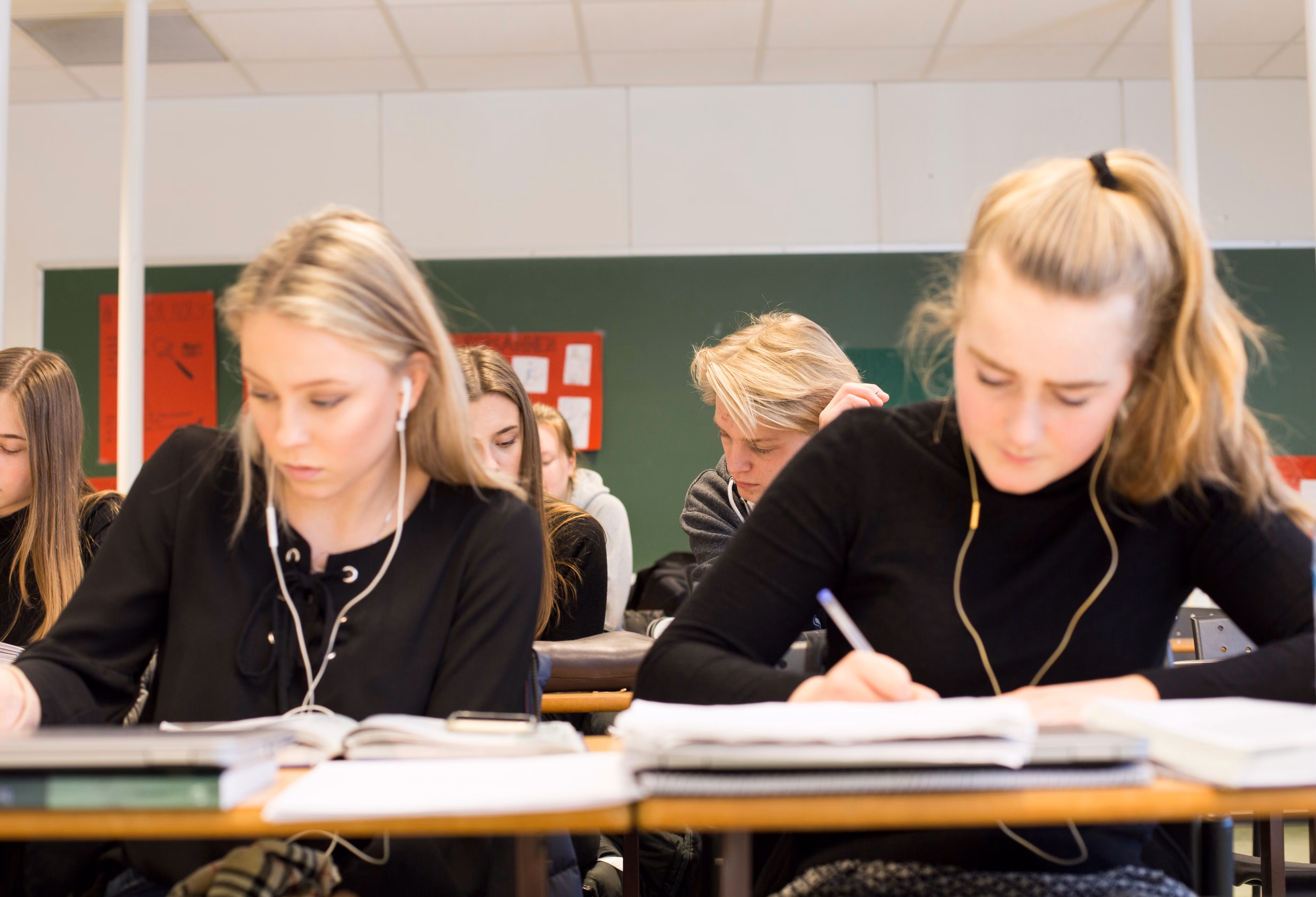To elever sitter i klasserommet og jobber konsentrert med matematikk.