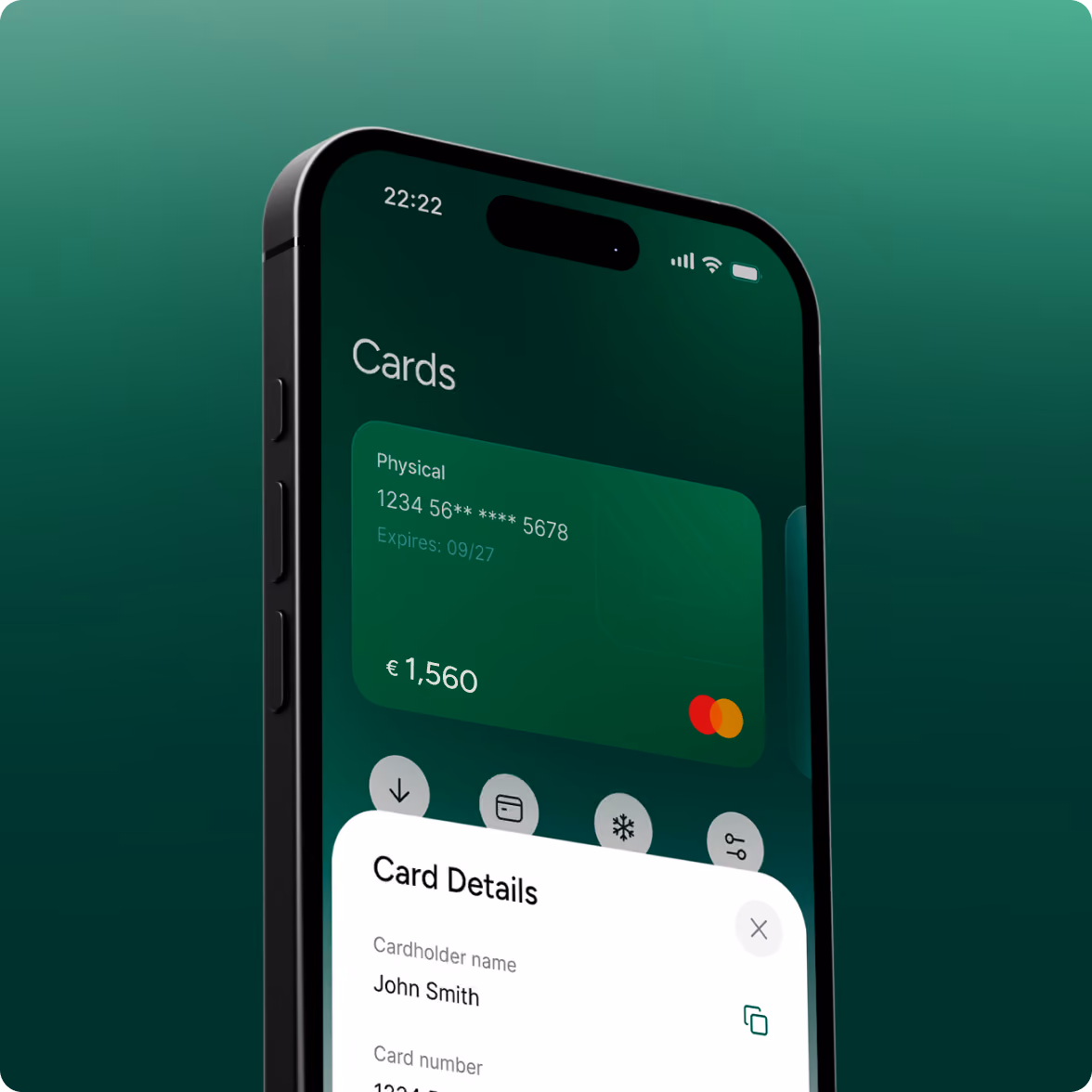 Smartphone screen showing an app interface with a green physical Mastercard card displaying a partially hidden card number, expiration date 09/27, and balance €1,560. Below the card, a white overlay panel titled Card Details shows the cardholder name John Smith and partially visible card number.