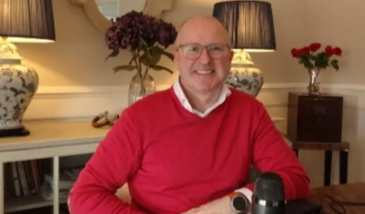 Stephen Adams at his desk with a podcast microphone, 2022
