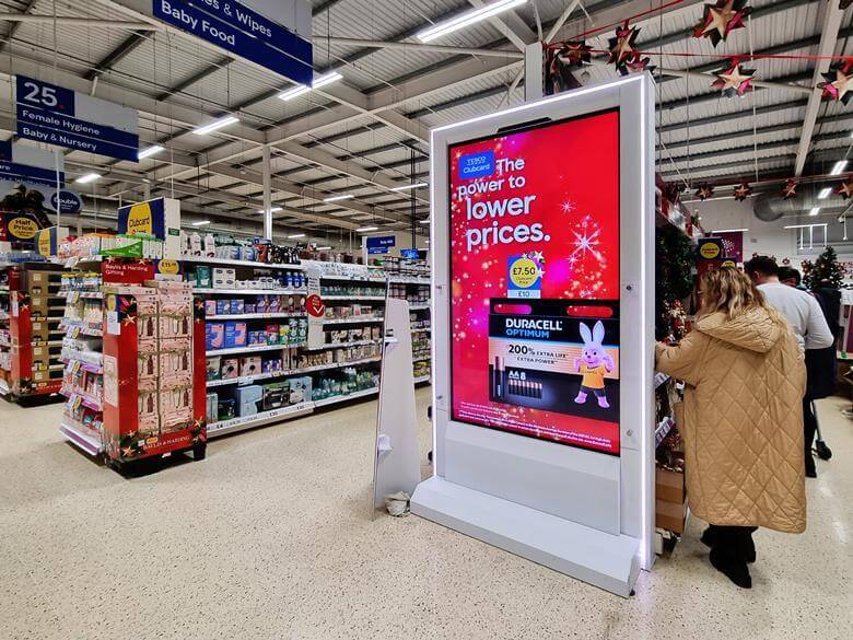 Virtual display ad screen at Tesco showcasing Duracell batteries at the end of an aisle