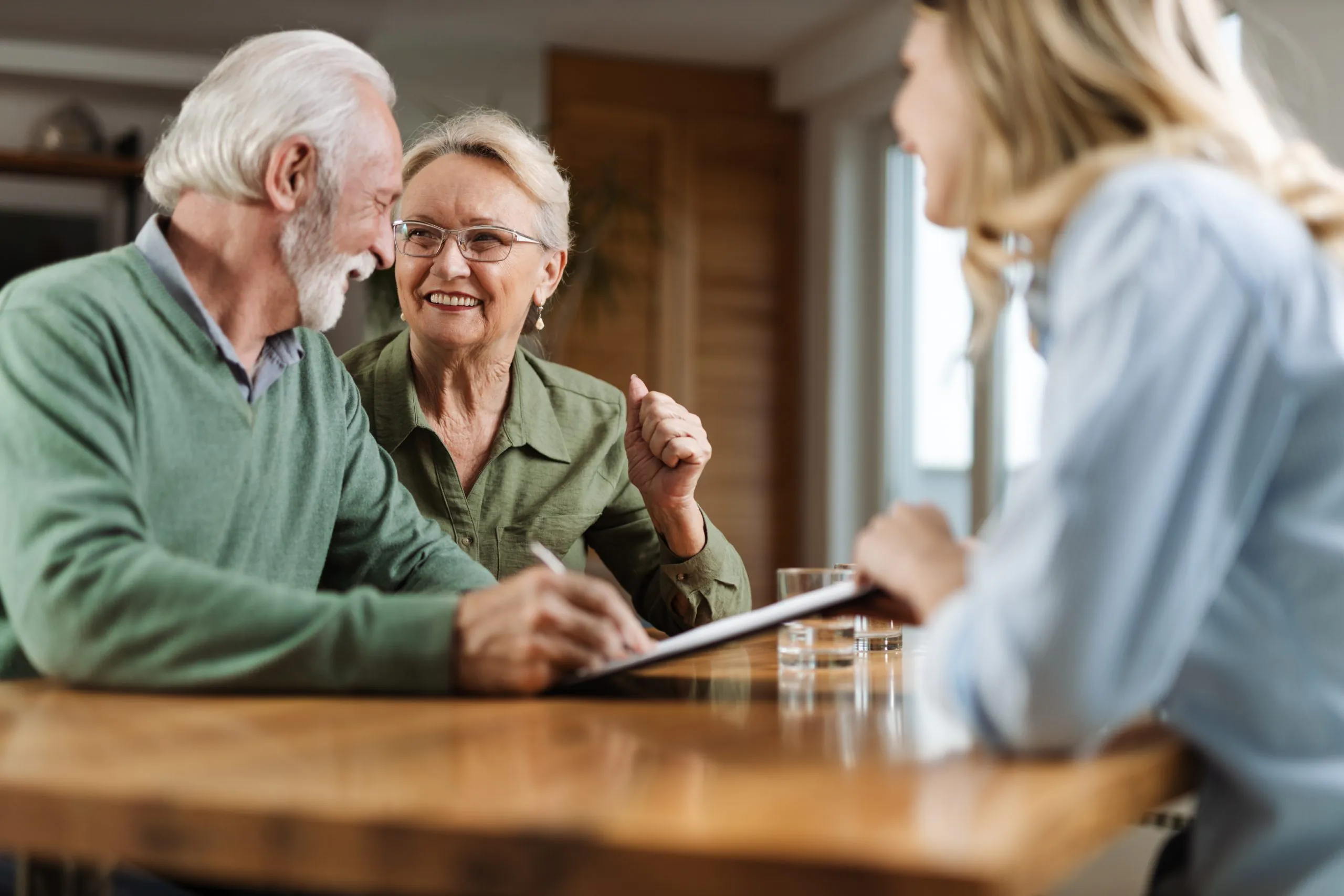 Happy mature couple signing a contract with their insurance age