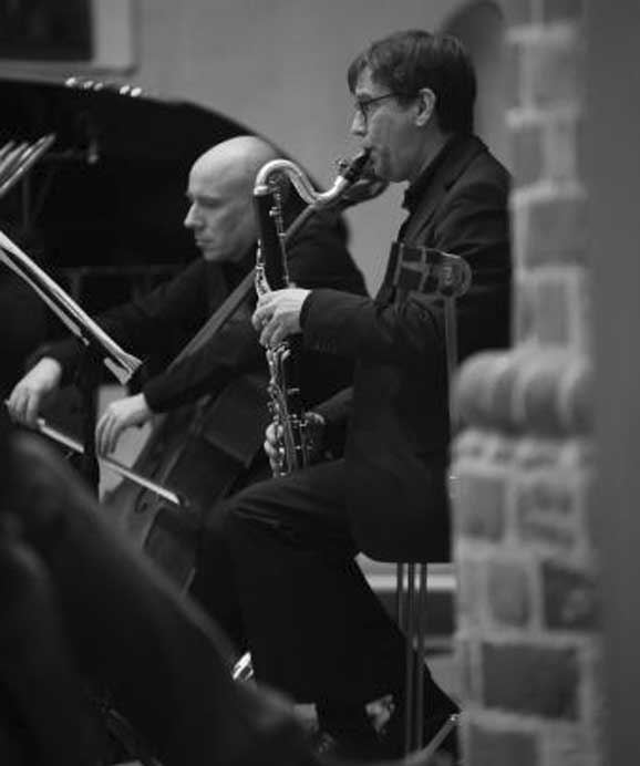 Zwei Musiker spielen Klarinette und Cello bei einem Auftritt in Schwarzweiß.