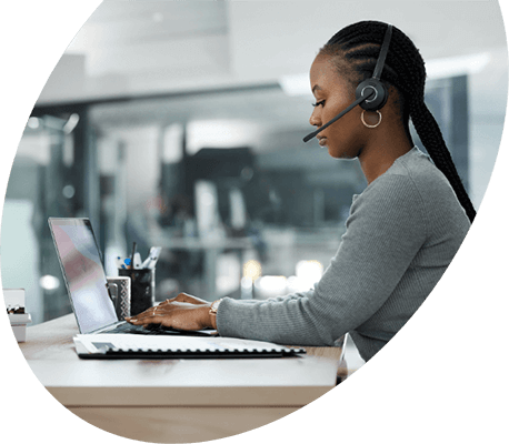 Customer support agent with a headset working on a laptop