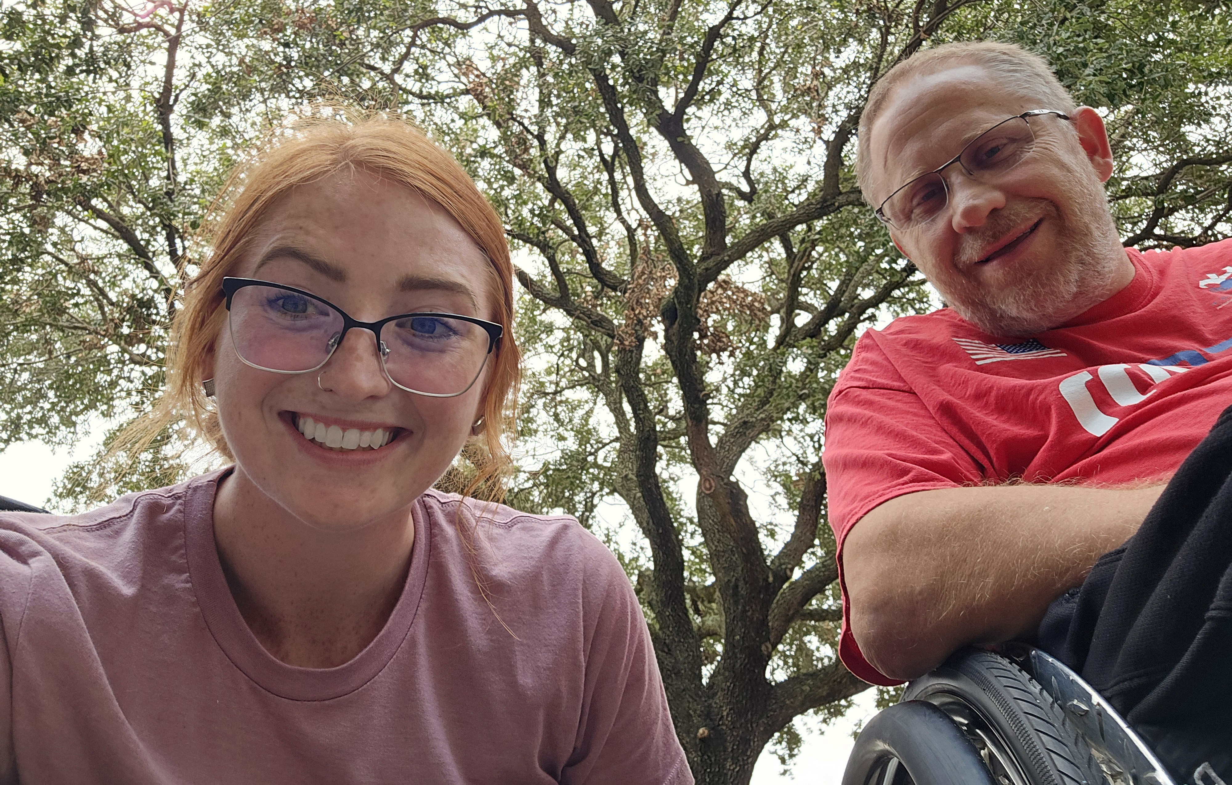 Nick and his caregiver underneath a large tree