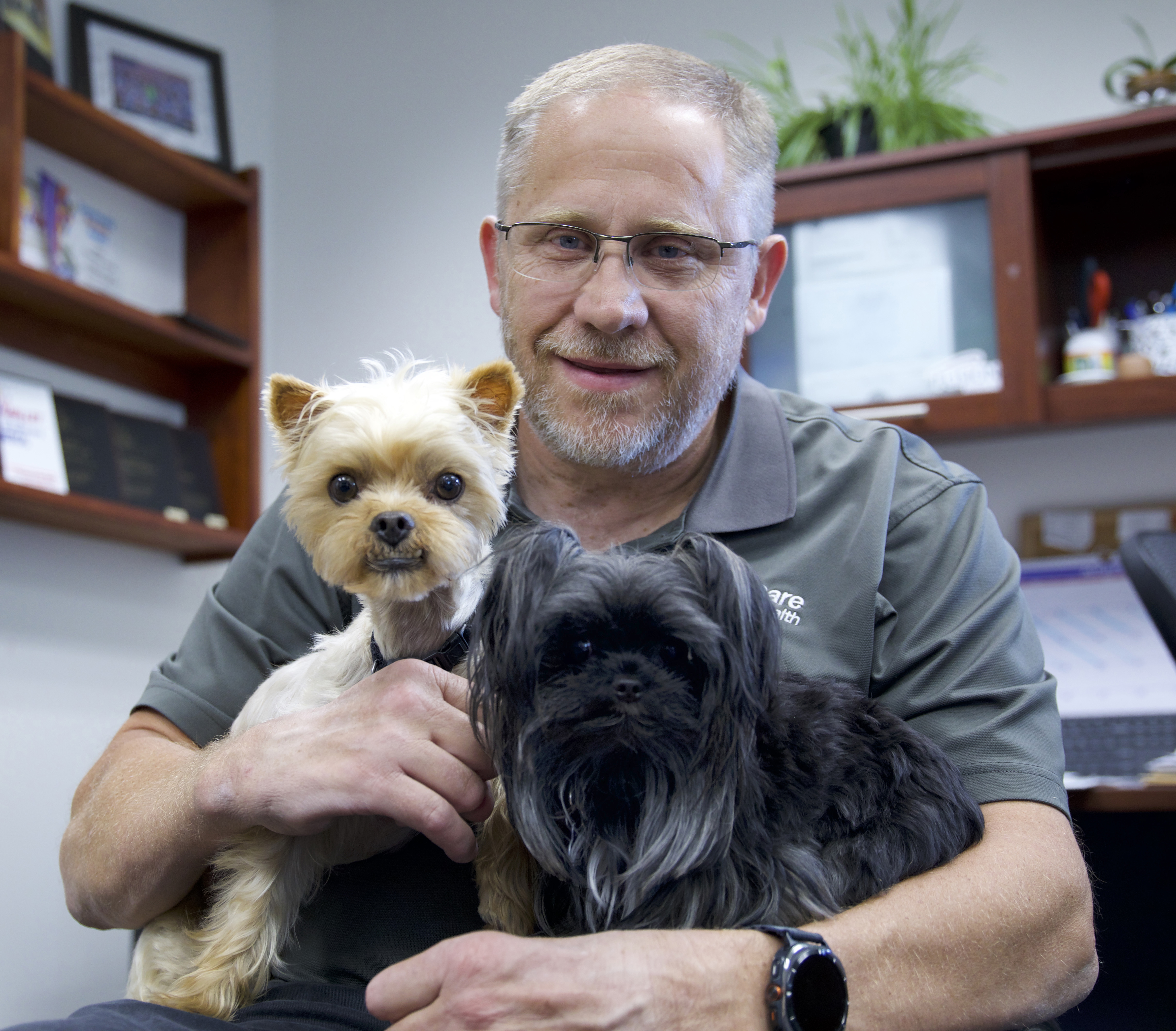 Nick and NeuroCare work dogs hanging in his office