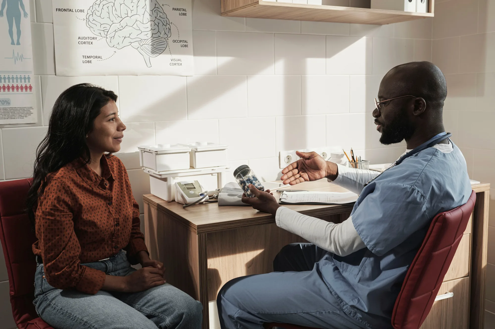 A clinician talking with a patient in a sunlit consulting room