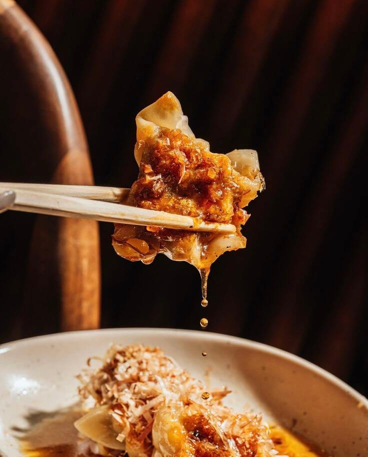 Gyoza lifted with chopsticks
