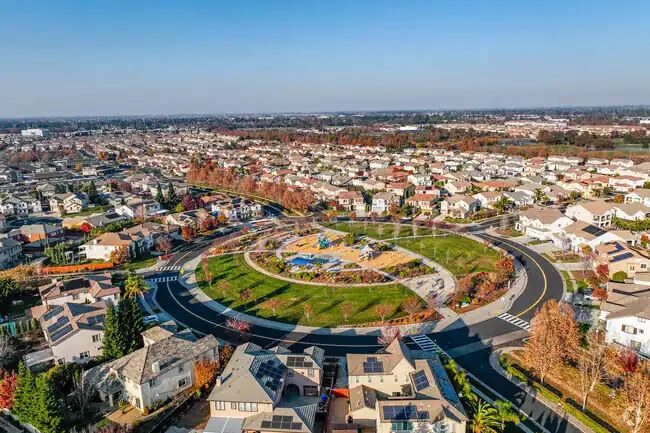 Aerial view of suburban neighborhood with a large circular park and playground in the center.