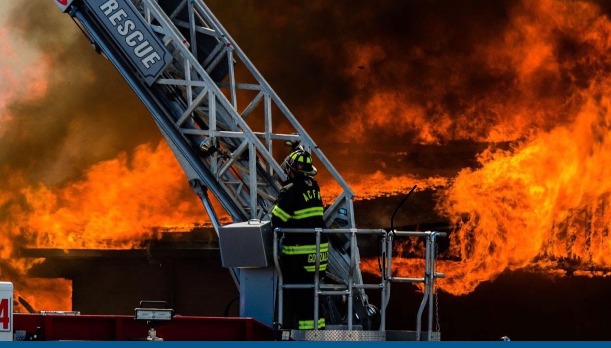 Firefighters use hose lines to extinguish flames at a burned structure