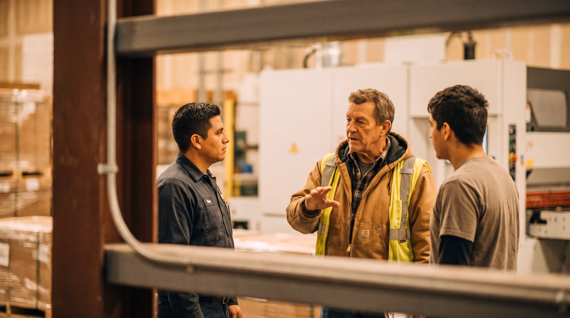 Supervisor leading a shift briefing with workers on a plant floor