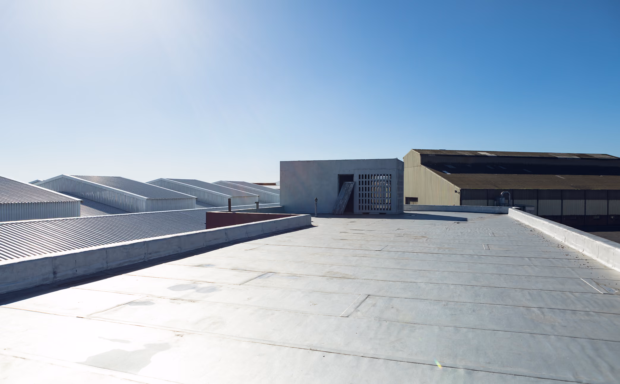 Exterior view of a commercial warehouse building with visible roofing structure.