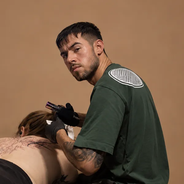 Tattoo Artist Asti bei der Arbeit am Rücken einer Kundin im Tattoostudio INK SOCIETY in Kiel