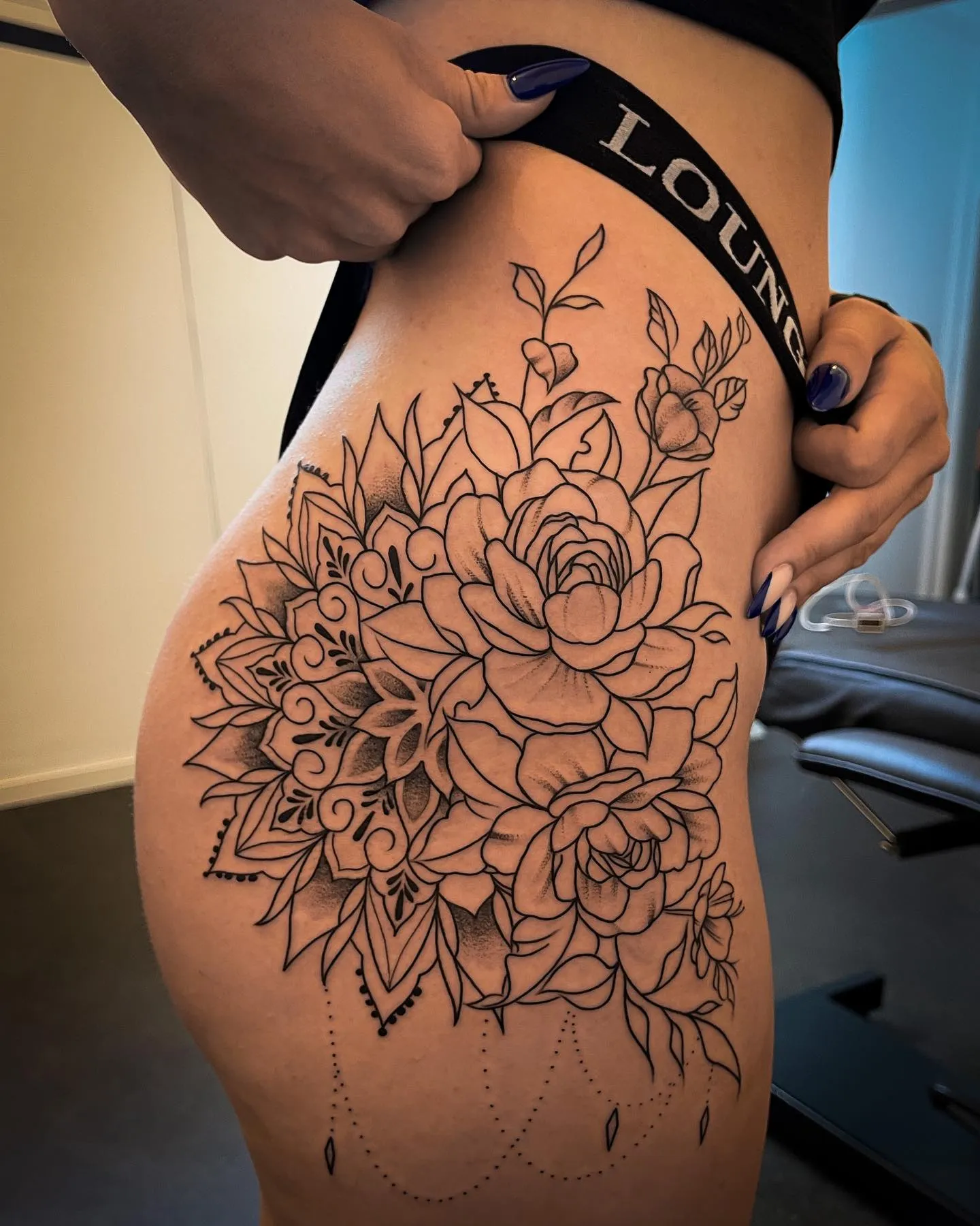 Ornamentales Blumen Tattoo an Hüfte und Oberschenkel – Pfingstrosen mit Mandala, Dotwork und Perlenketten, INK SOCIETY