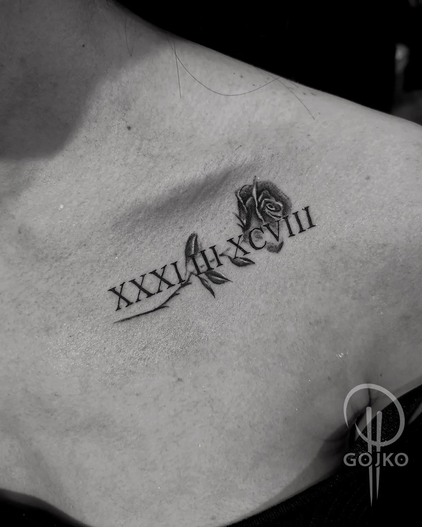 Römische Zahlen Tattoo mit Rose am Schlüsselbein – kleines Black and Grey Datum Tattoo von Gojko, INK SOCIETY