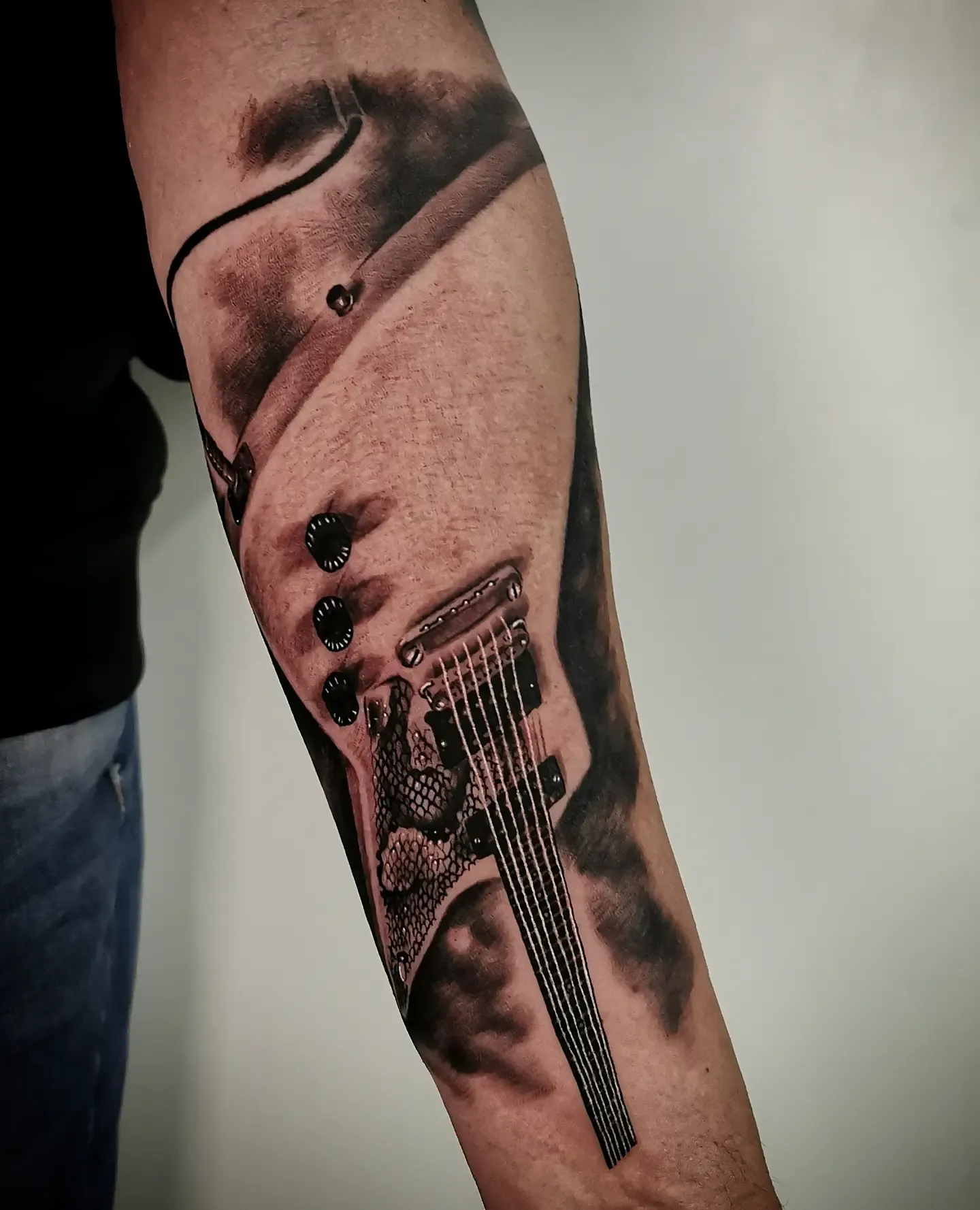 Realistisches Black and Grey Gitarren Tattoo am Unterarm – E-Gitarre mit Saiten, Reglern und Schlangenhaut-Muster, INK SOCIETY