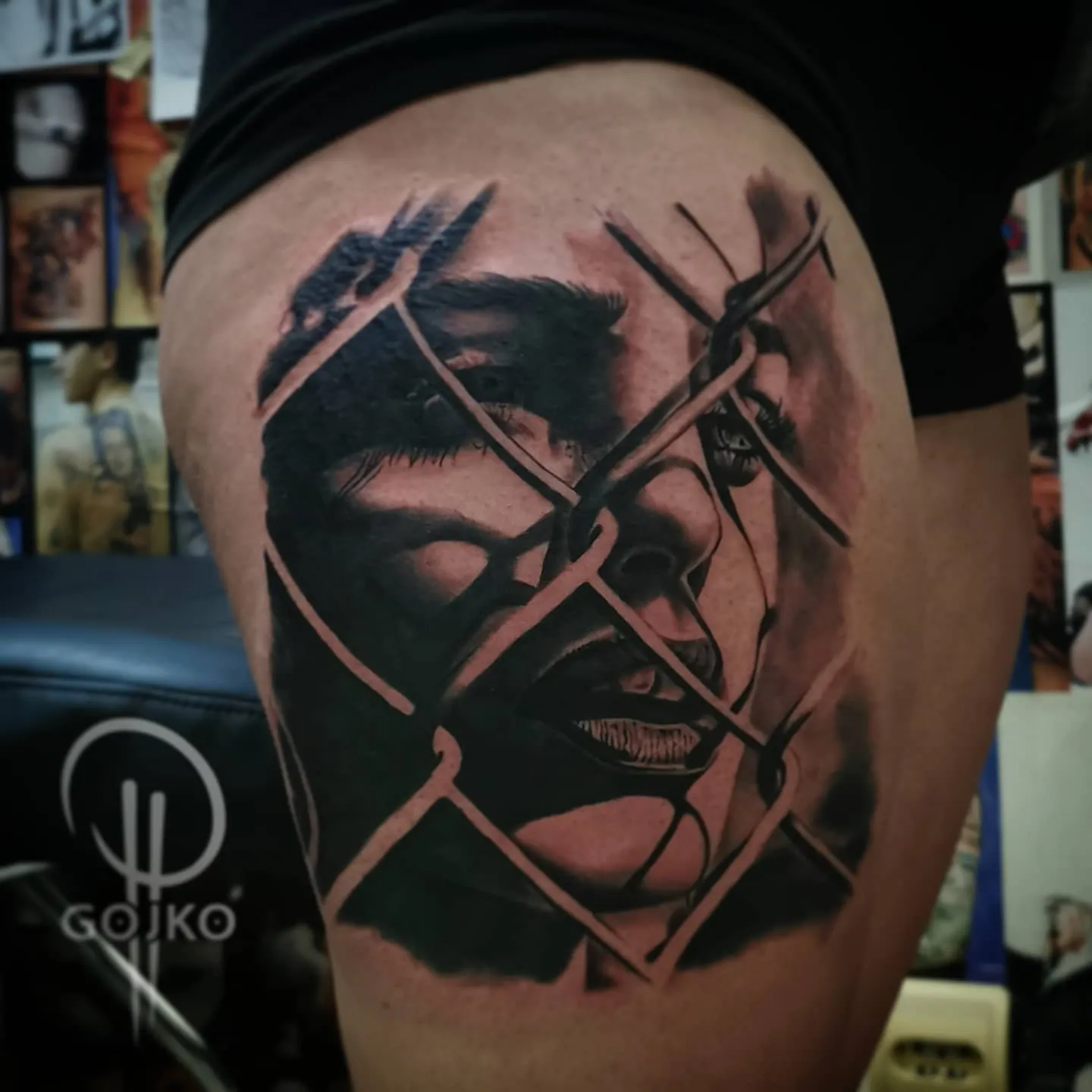Realistisches Black and Grey Portrait Tattoo am Oberschenkel – Frauengesicht hinter Maschendrahtzaun, von Gojko, INK SOCIETY