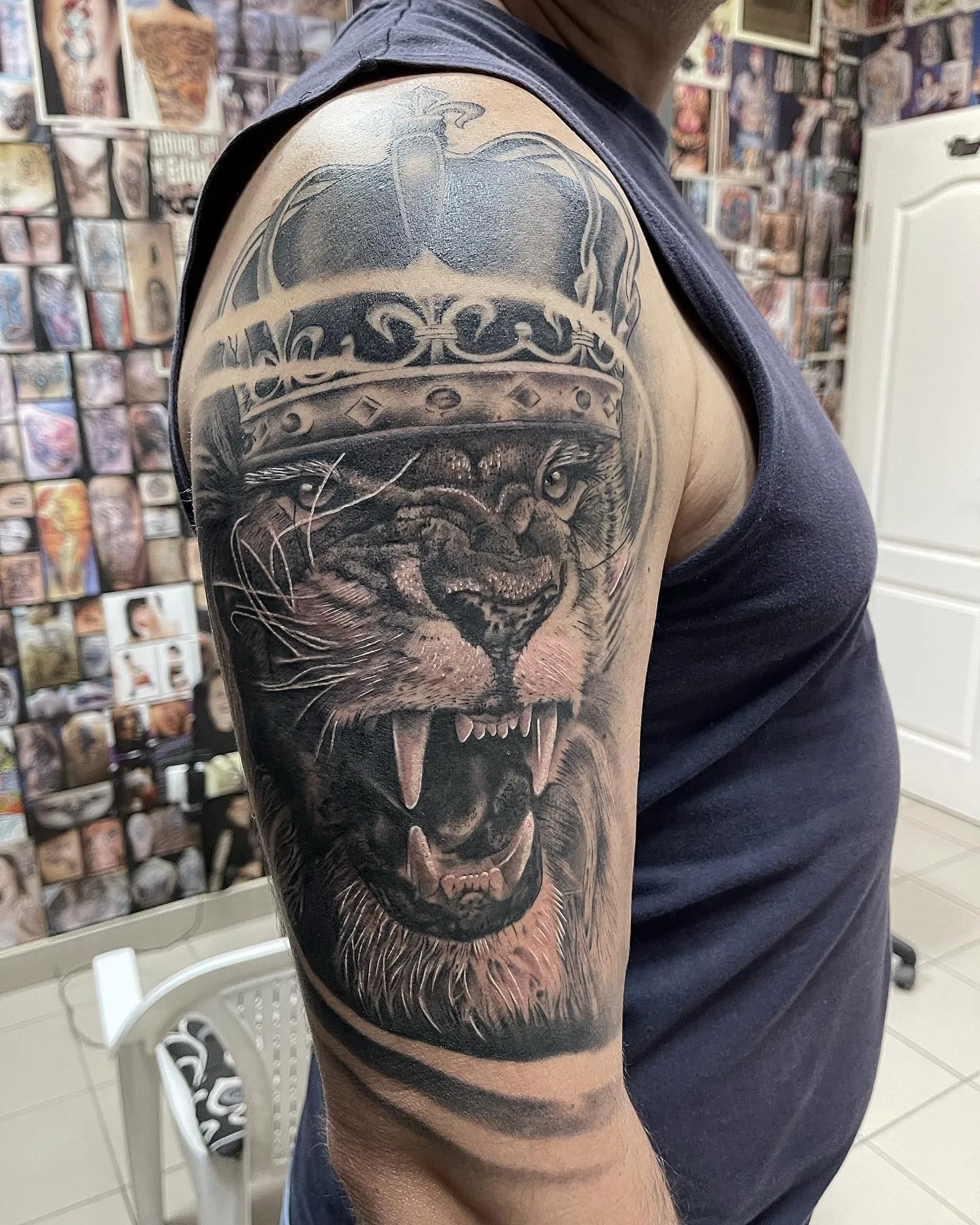 Realistisches Black and Grey Löwen Tattoo an Schulter und Oberarm – brüllender Löwe mit Krone, INK SOCIETY