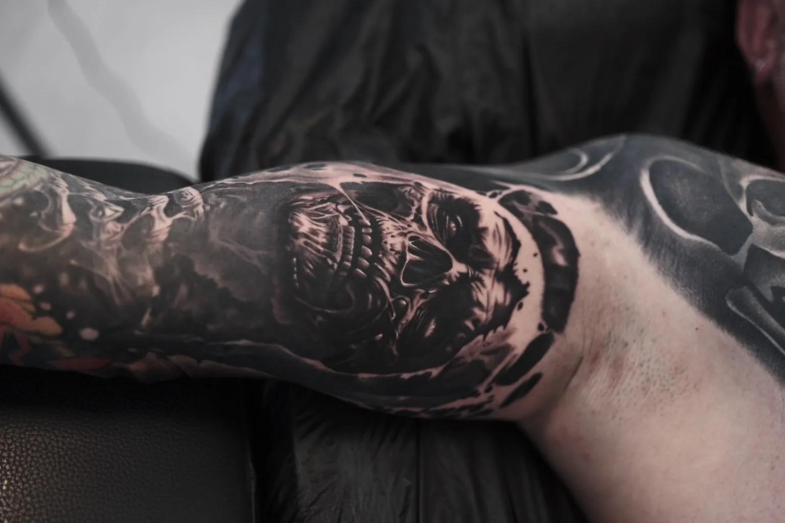Realistic Black & Grey Sleeve Tattoo mit Totenkopf am Bizeps, INK SOCIETY Kiel