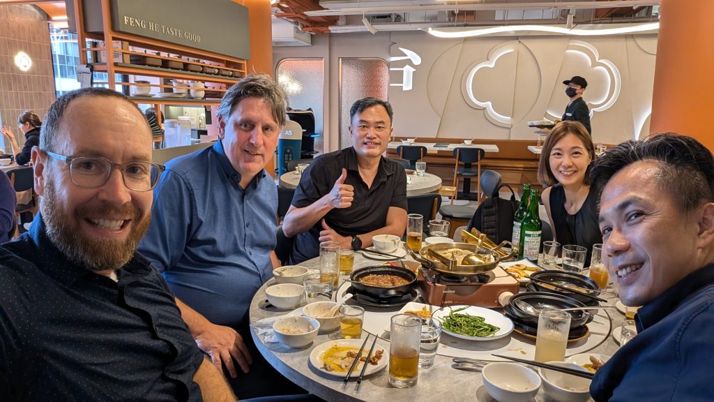 Co-founders Kyle, Luke and Amos sitting around a dinner table celebrating with our new manufacturing partners.