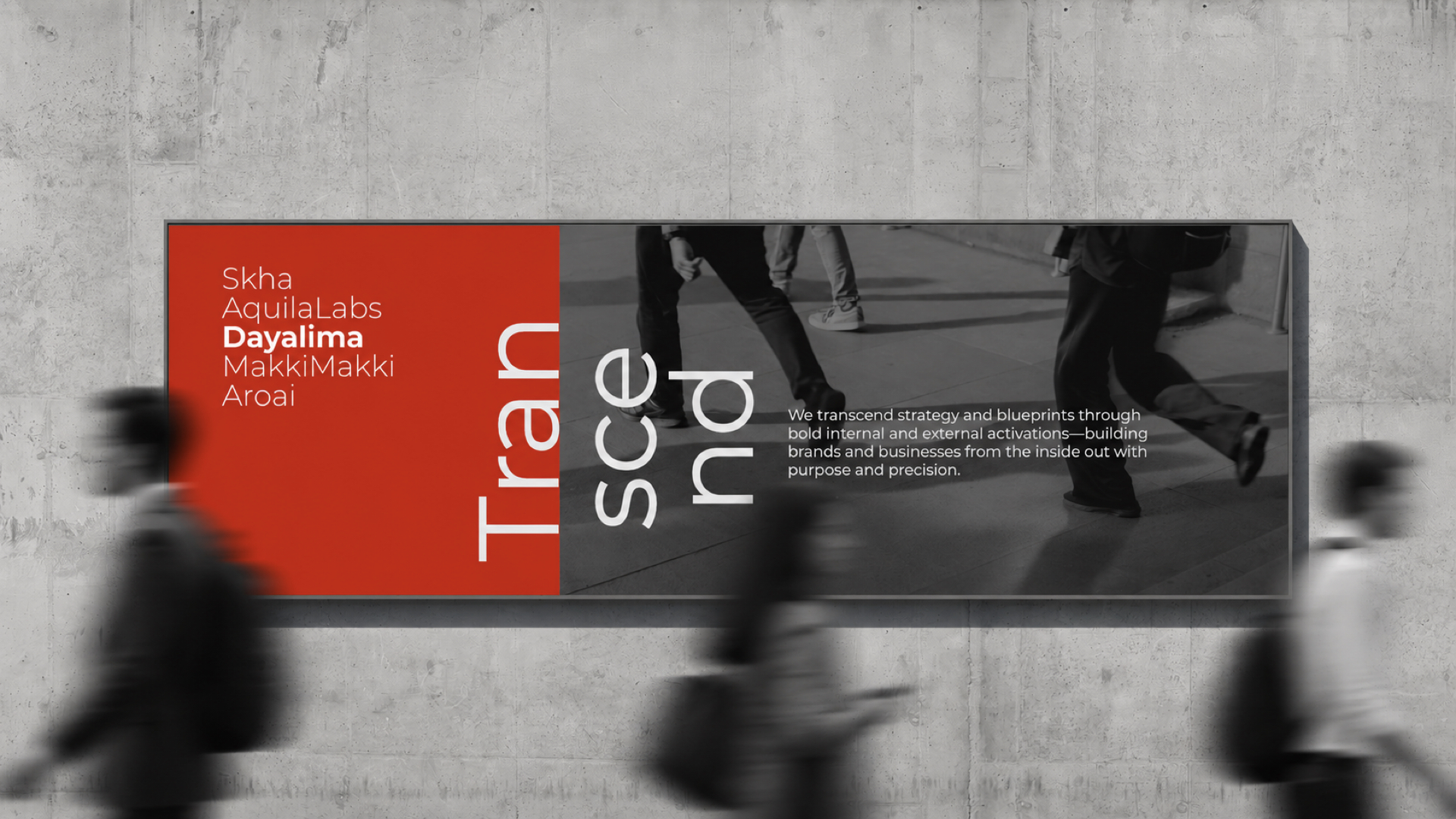 Wall billboard with a red and black background featuring text including company names—Skha, AquilaLabs, Dayalima, MakkiMakki, Aroai—and the words 'Transform, ascend.' The billboard also includes a statement about transcending strategy and blueprints through bold internal and external activations to build brands and businesses with purpose and precision. Blurred figures of people walking past the billboard are visible.