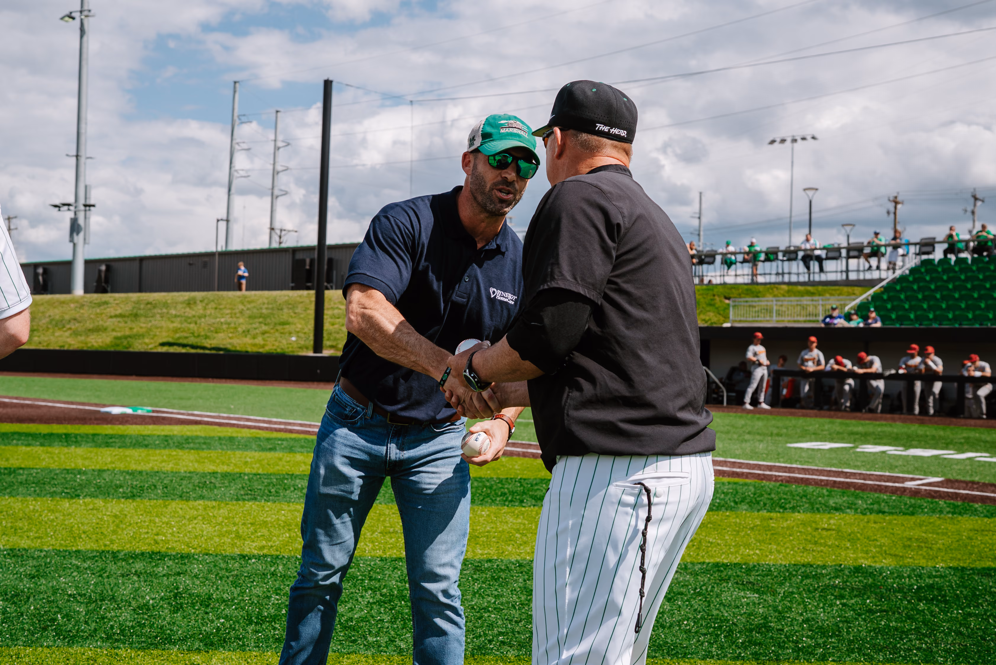 Image of Chris Lowe shaking hands with a Marshall baseball coach.