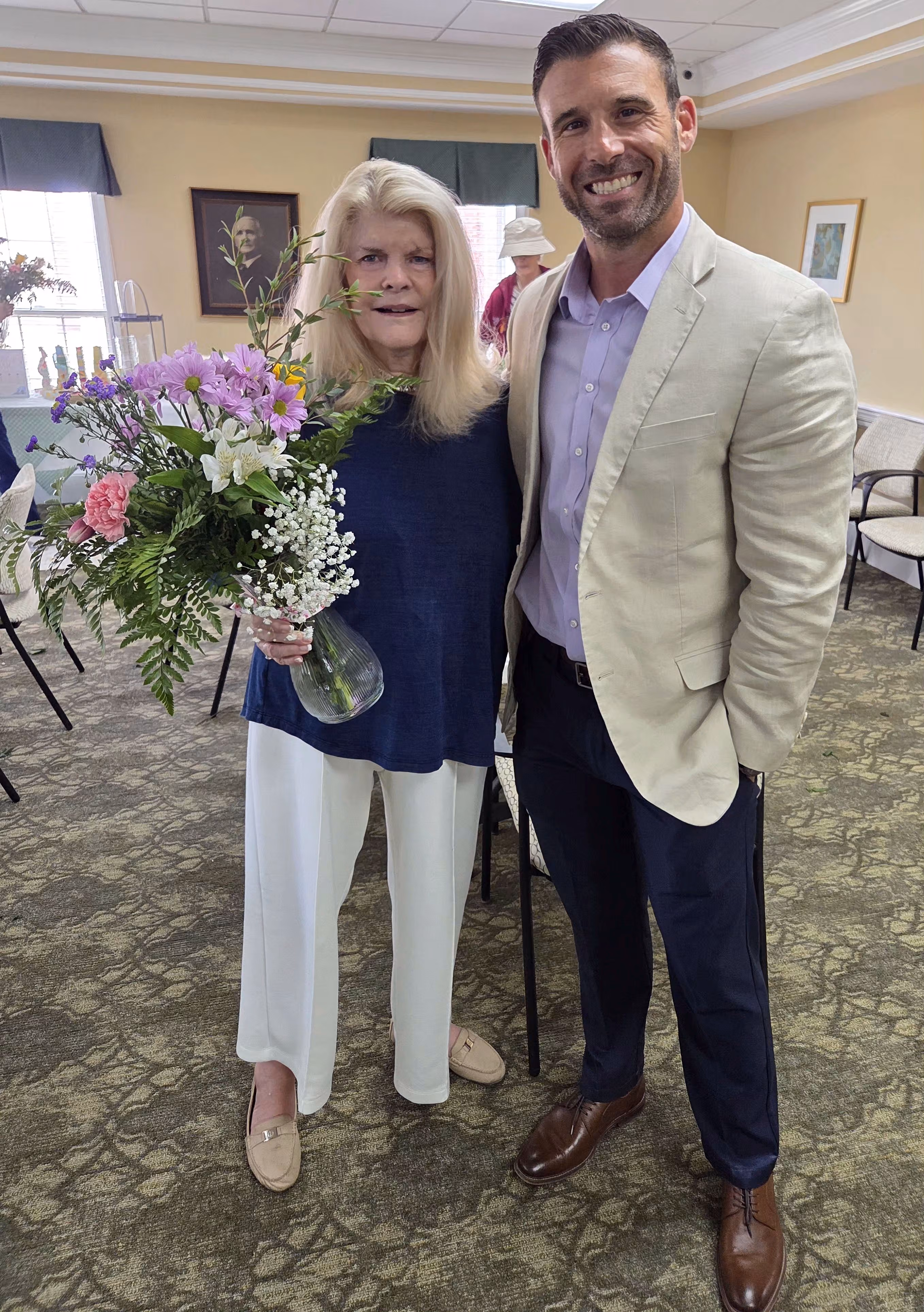 Image of a woman standing with SYNERGY® HomeCare owner Chris Lowe.