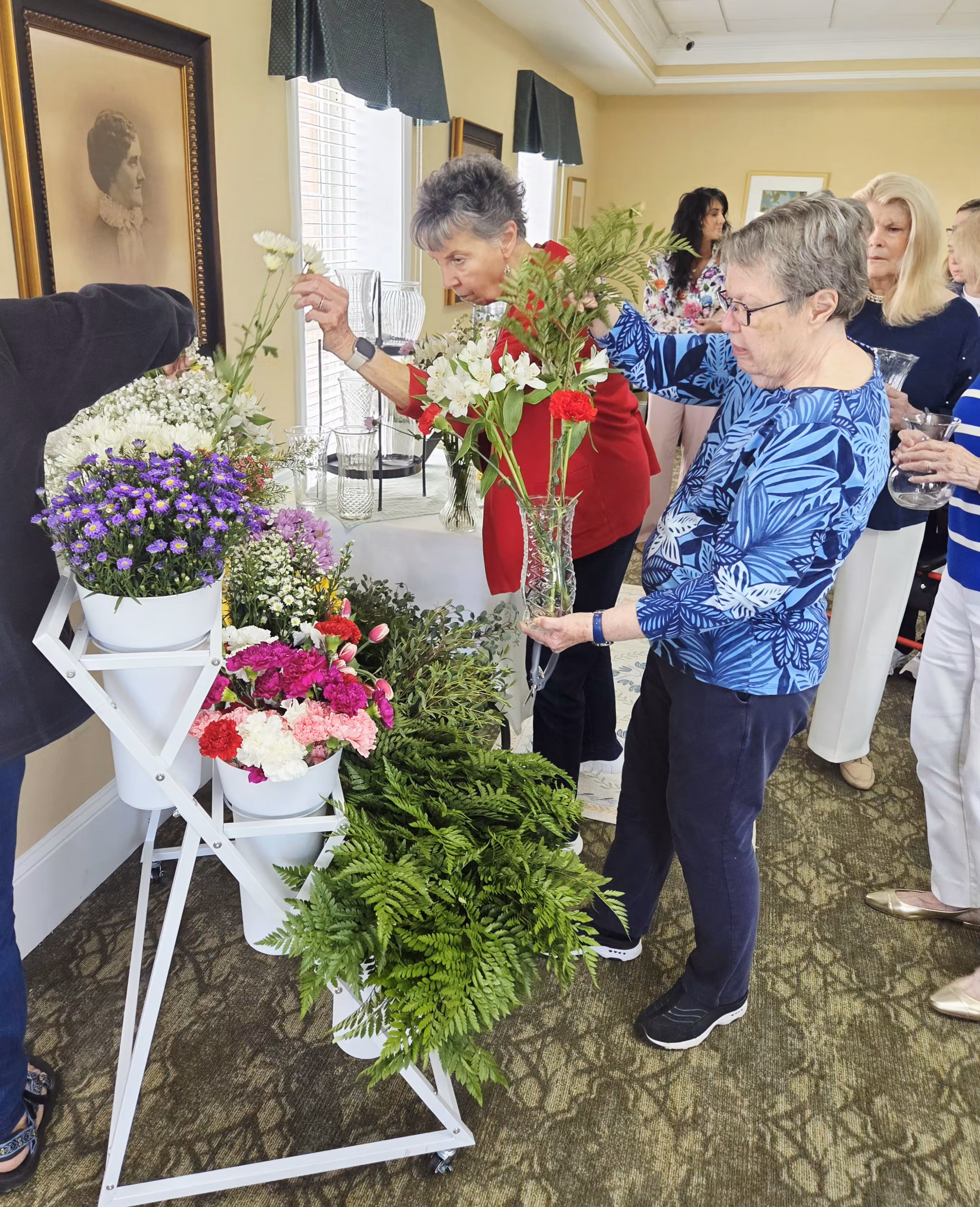 Image of women looking at different types of flowers in a display.