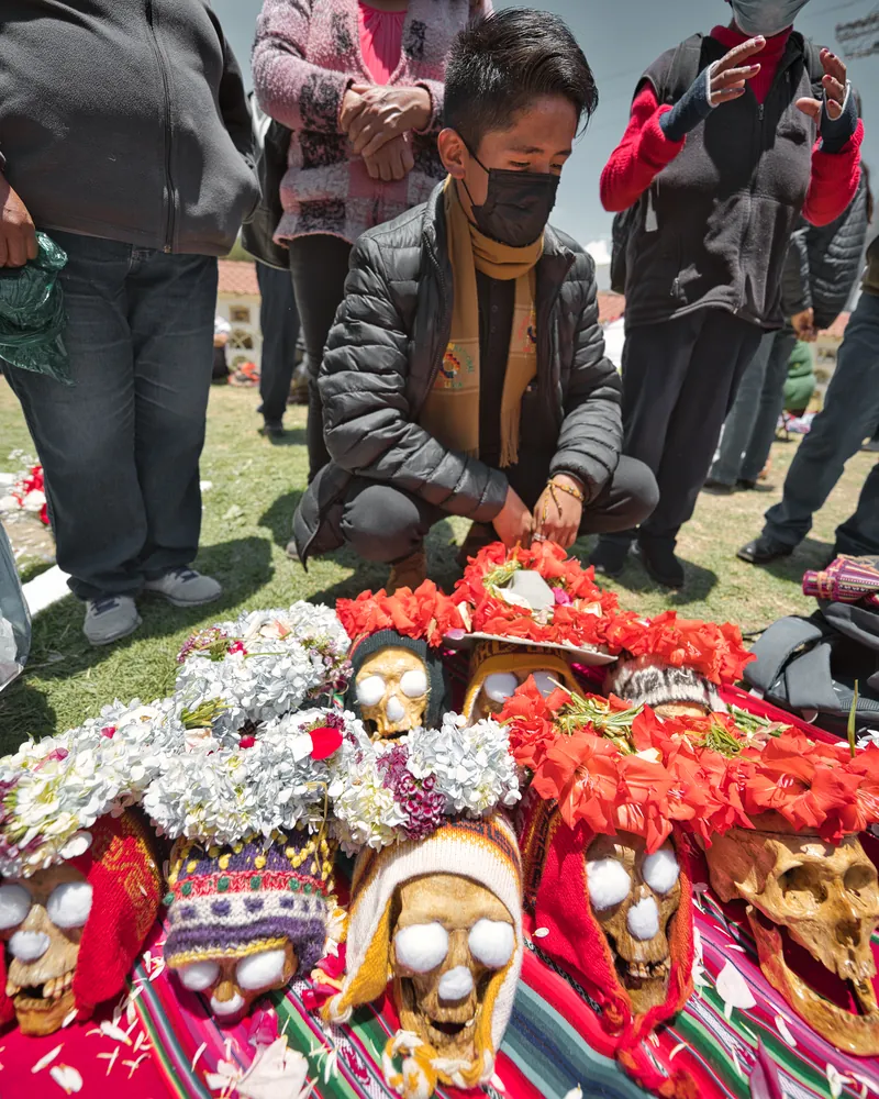 Photo of a devotee arranging decorated skulls during the Ñatitas festival. Fiesta de las Ñatitas tour La Paz