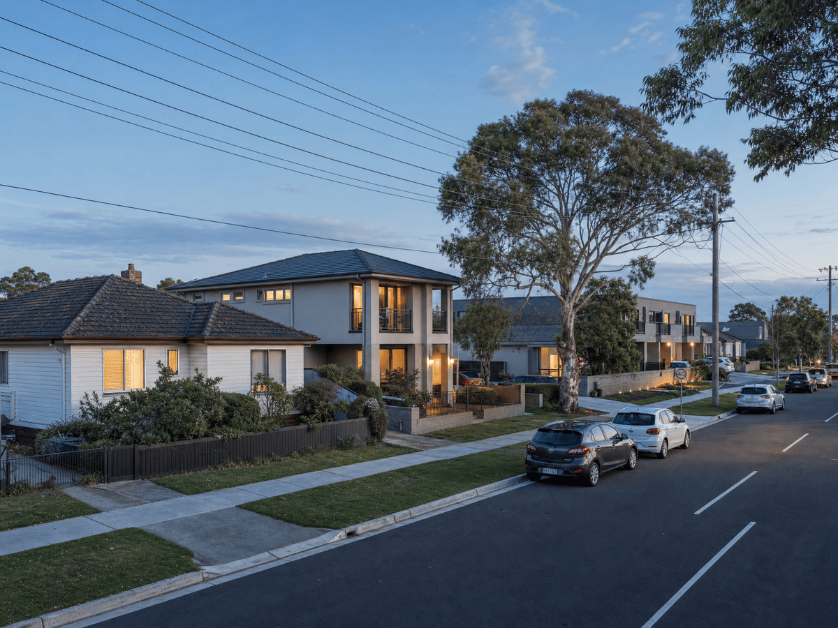 Occupied modest houses and units on a Newcomb street at early evening, hinting at workable rental income and tenant demand at an accessible price point.