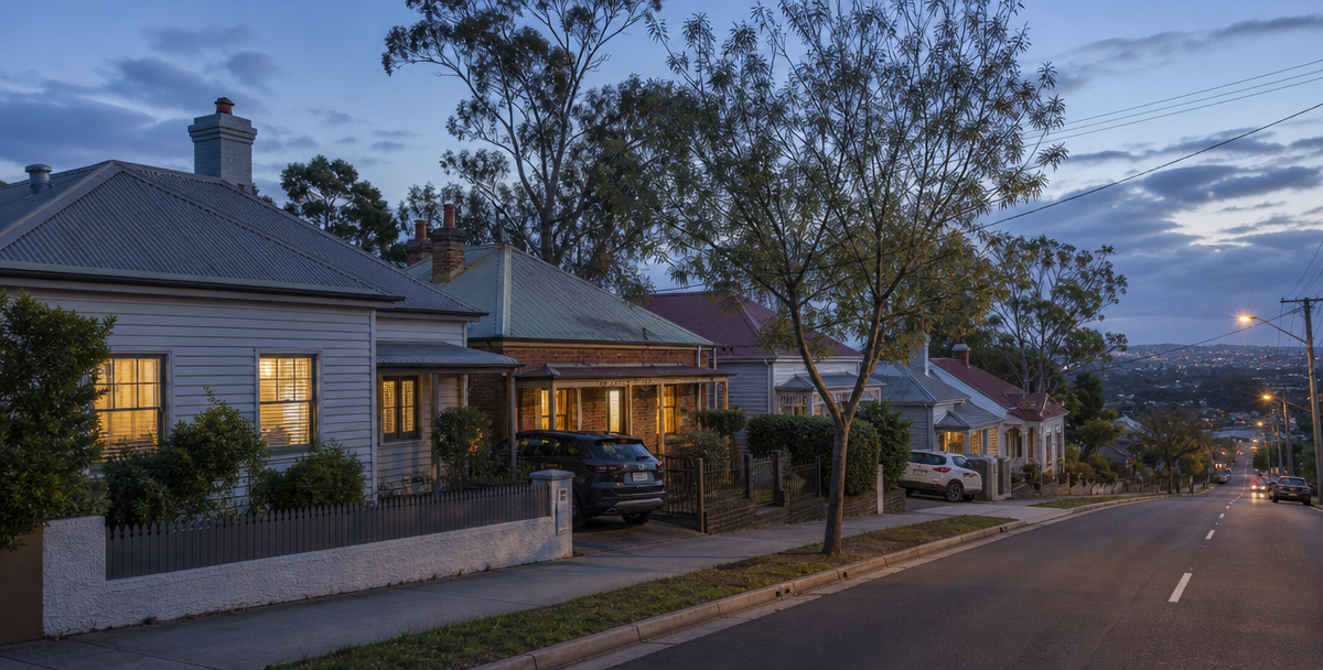Occupied heritage cottages on a sloping Launceston street at early evening, suggesting the steady tenant demand behind the city's rental yields.png