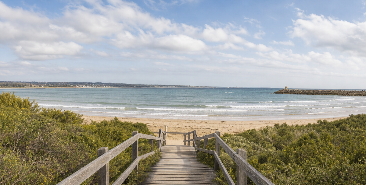 A boardwalk path through coastal scrub toward the beach on the ellarine Peninsula near Geelong