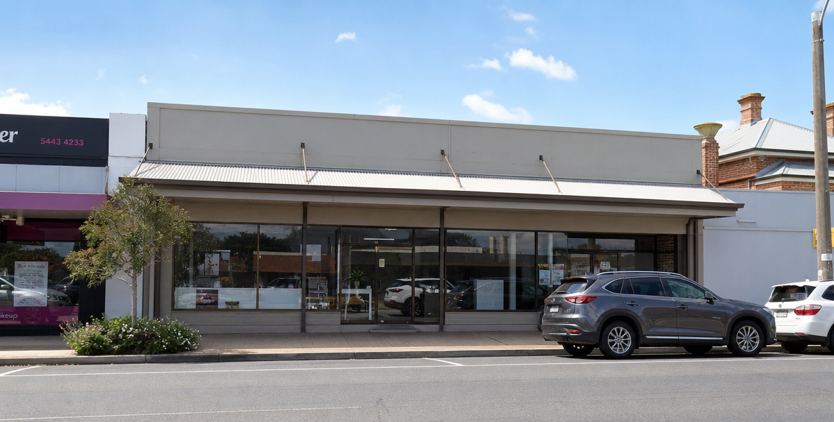 A  modest commercial shopfront on a quiet Australian suburban street, reflecting commercial property as one of the property types investors can choose.