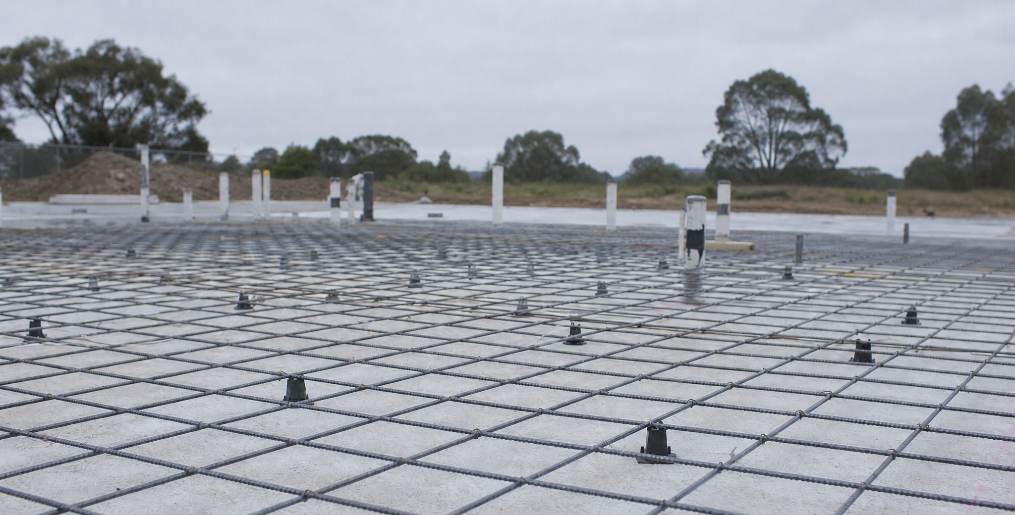 A reinforced concrete slab foundation before the pour on an Australian building site, reflecting the ownership structure decided before a property purchase.