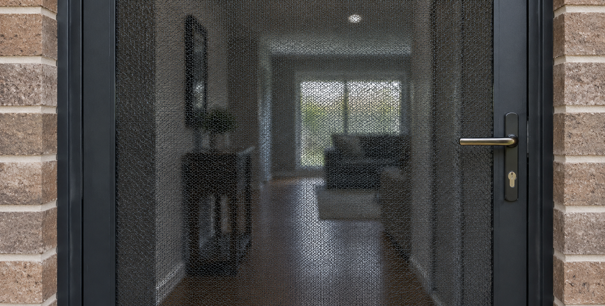 A close view through the mesh of an Australian security screen door, reflecting how a buy-box filters listings during the search.