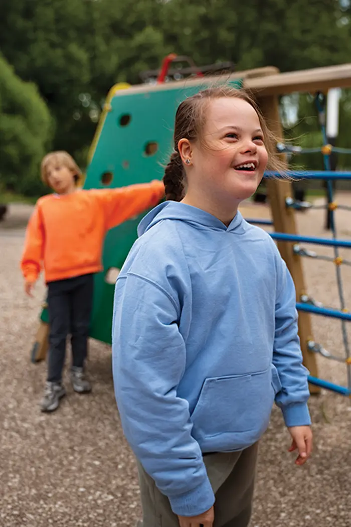 A child smiling on a playground climbing frame