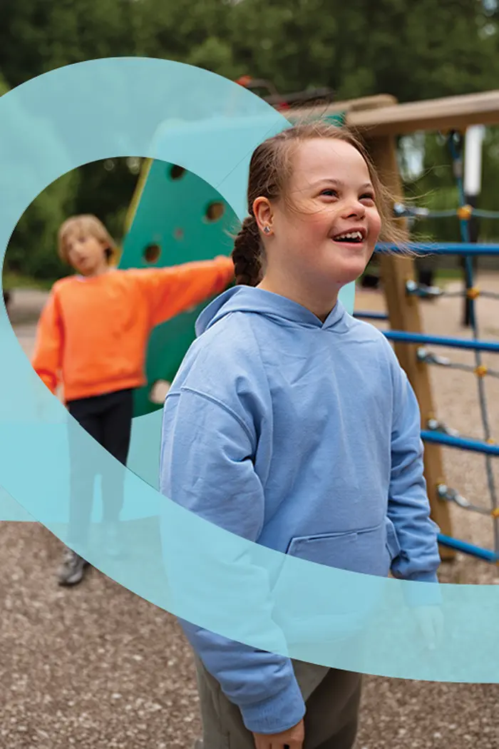 A child smiling on a playground climbing frame