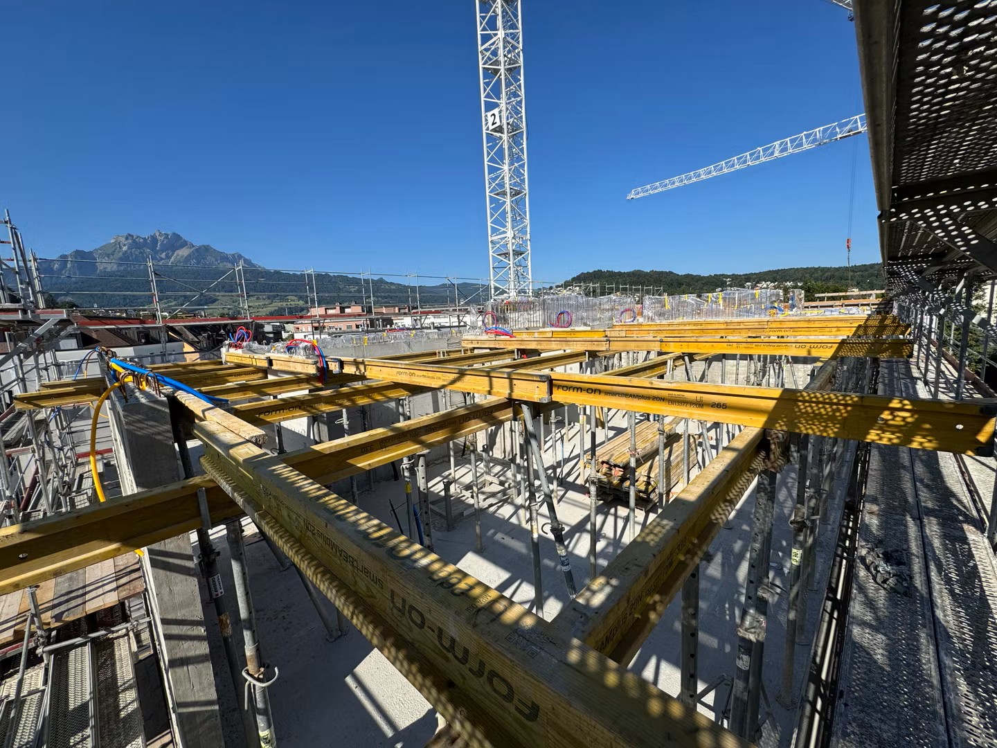 Auf der Baustelle geht es weiter hoch hinaus: Die Decke über dem 4. Obergeschoss ist betoniert und im 5. Obergeschoss entstehen bereits die nächsten Wände. Auch die Schalungsarbeiten für die nächste Decke sind in vollem Gange.
Parallel dazu wird im Untergeschoss fleissig weitergearbeitet. Die Betonwand sowie die beiden Rampen werden aktuell armiert und die Betonsanierungsarbeiten stehen kurz vor dem vollständigen Abschluss.
Auch die Vorbereitungen für die Fassade schreiten voran: Vom 1. bis zum 4. Obergeschoss wurden bereits die notwendigen Achsen für die späteren Einmessarbeiten erstellt.
So wächst nicht nur das Gebäude weiter in die Höhe – auch die nächsten sichtbaren Entwicklungsschritte rücken immer näher.