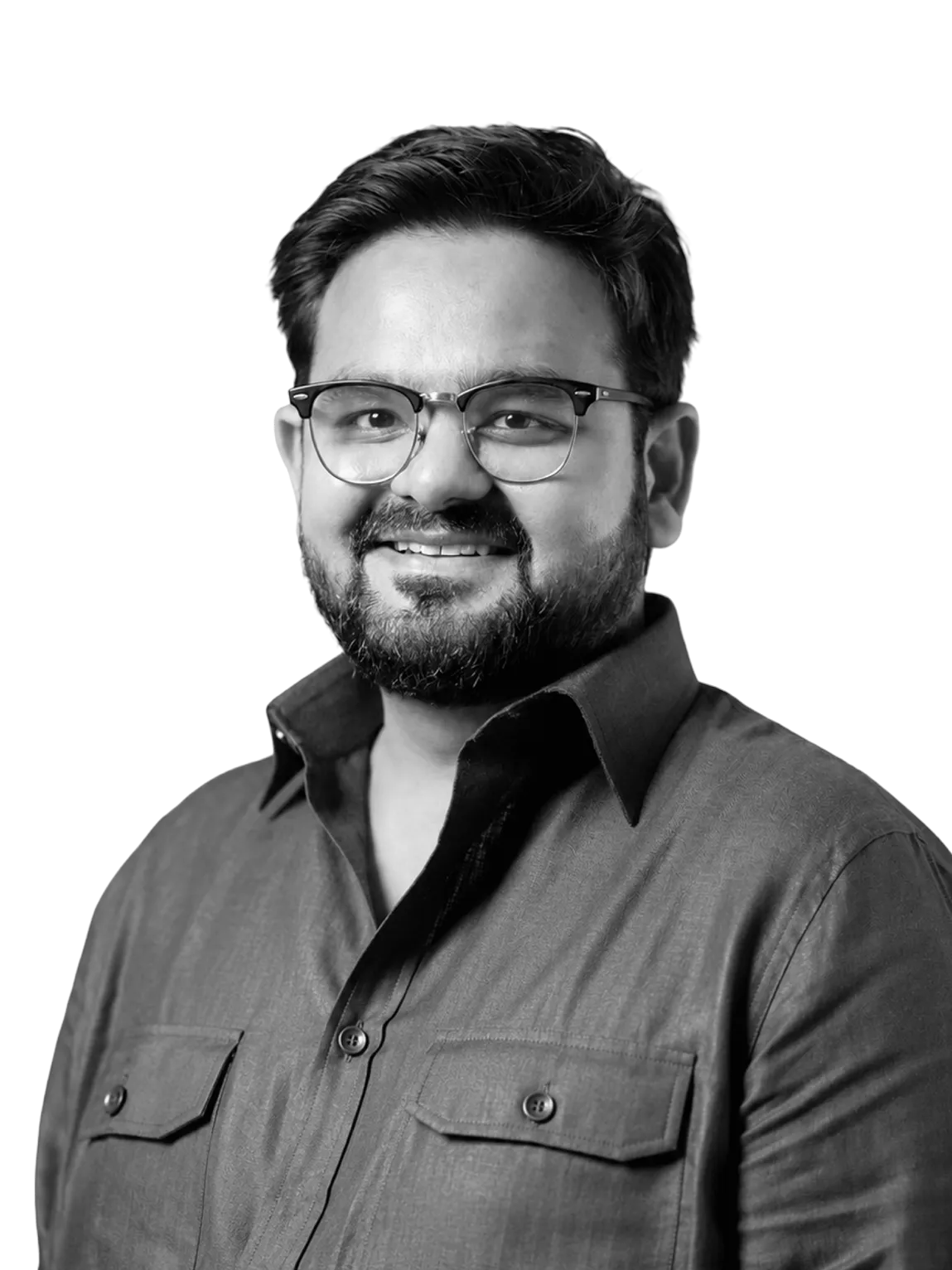 Smiling man with beard and glasses wearing a buttoned shirt, facing forward.