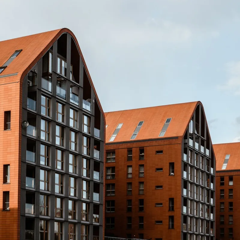 Three identical modern brick apartment buildings.