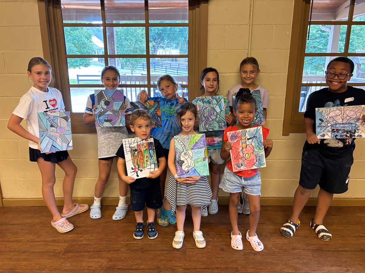 Kids of different backgrounds showing off their finished artwork