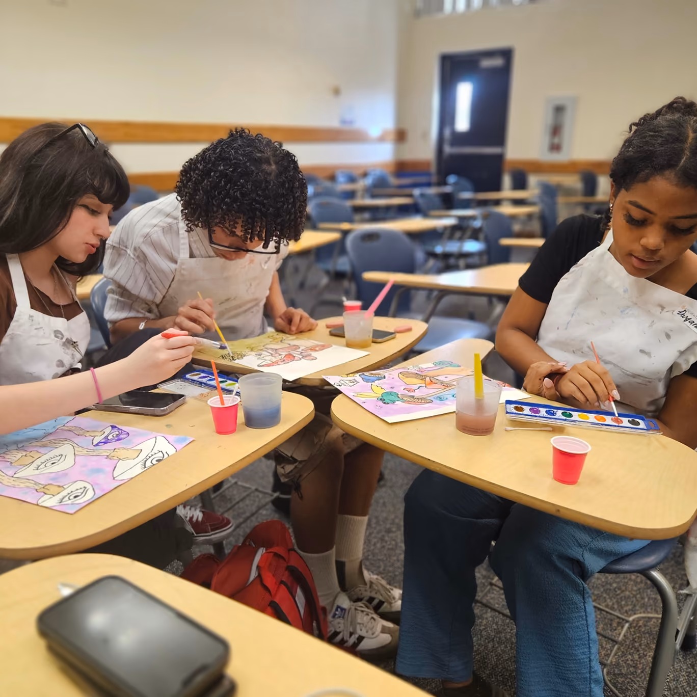 Older student concentrating on a watercolor painting in class
